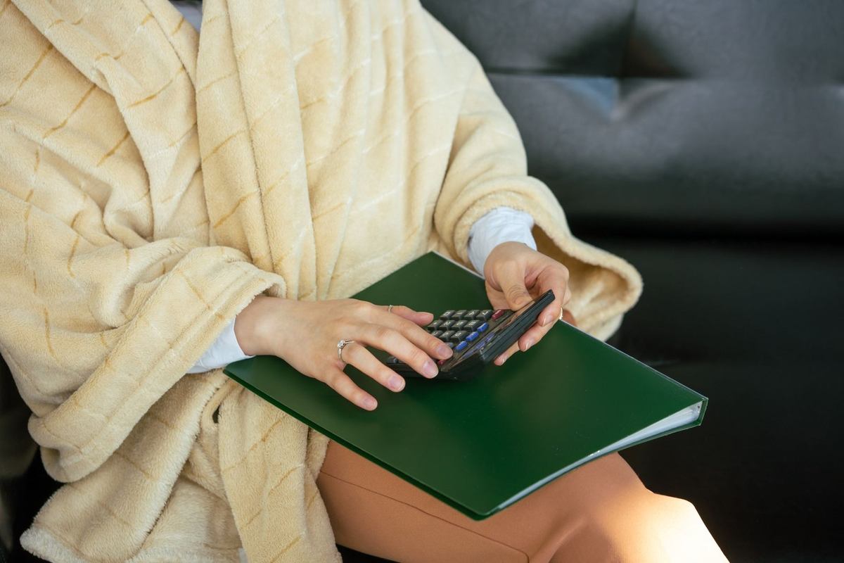 Individu en cape utilise un appareil sur classeur vert