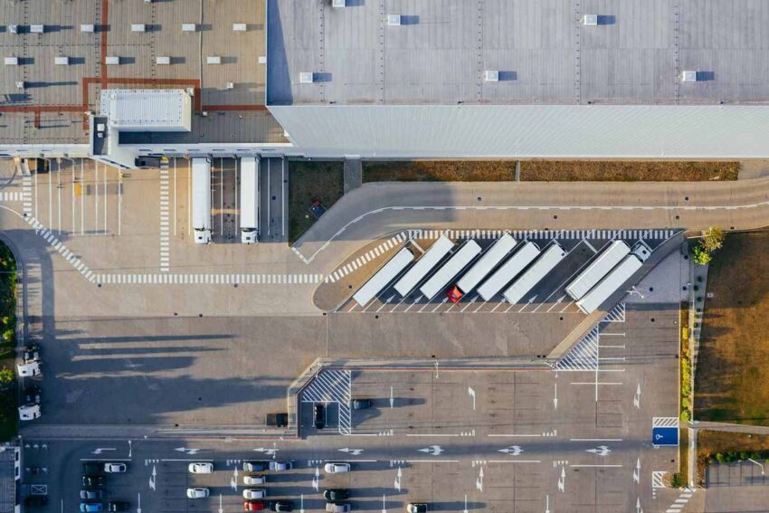 Vue aérienne montrant un bâtiment industriel, camions et parking