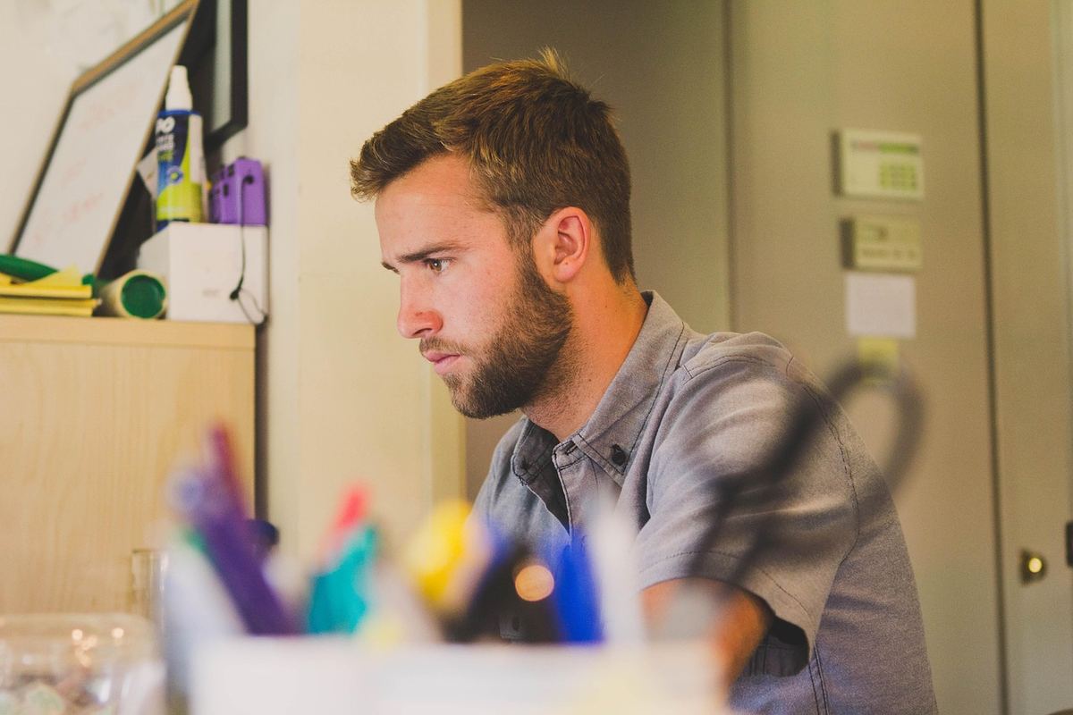 Un jeune homme avec barbe travaille dans un bureau coloré